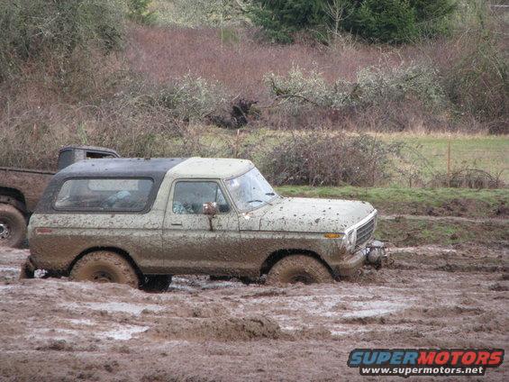 Mud-covered 1978 Ford Bronco stuck in mud, 3q-front view