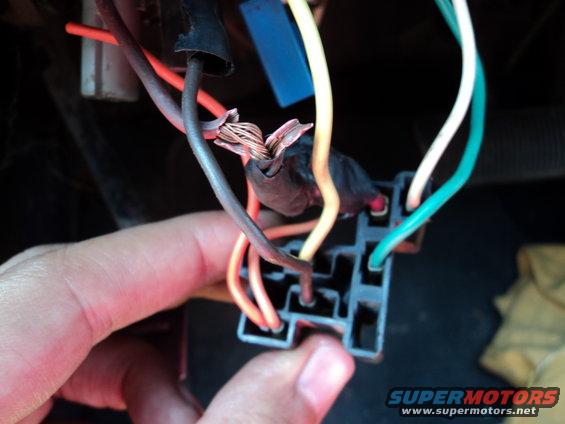 Close-up of a damaged wiring harness with exposed copper wires