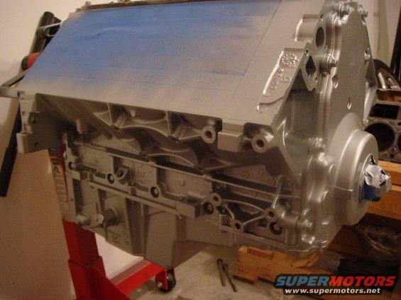 Silver engine block on red stand, partially taped