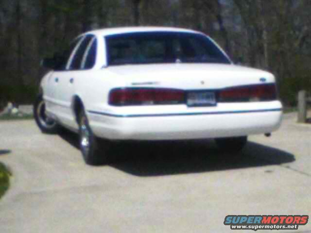 Rear view of a white sedan parked on a concrete surface