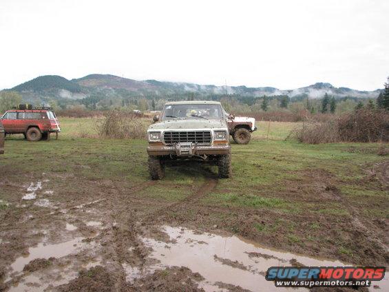 Green Ford F-Series truck with winch in muddy field