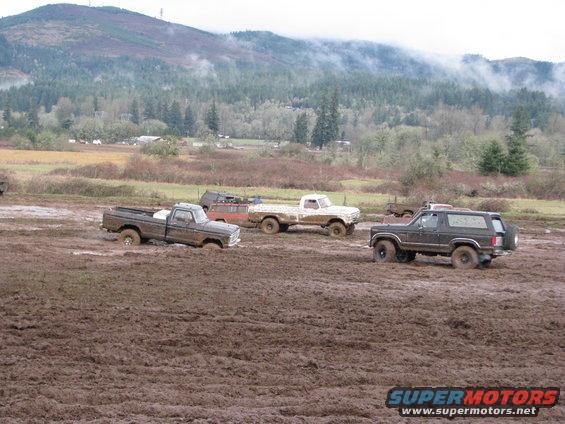 Dark 1978 Ford Bronco in mud, 3q-front view