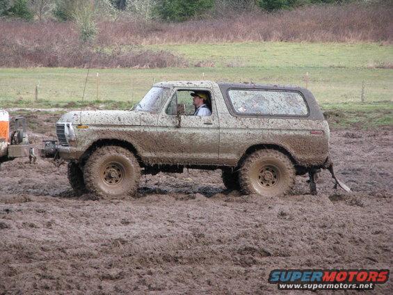 Mud-covered 1978 Ford Bronco driving through thick mud