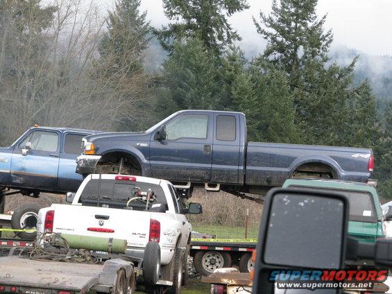 Blue Ford F-250 Super Duty pickup truck, missing front wheels, parked on trailers