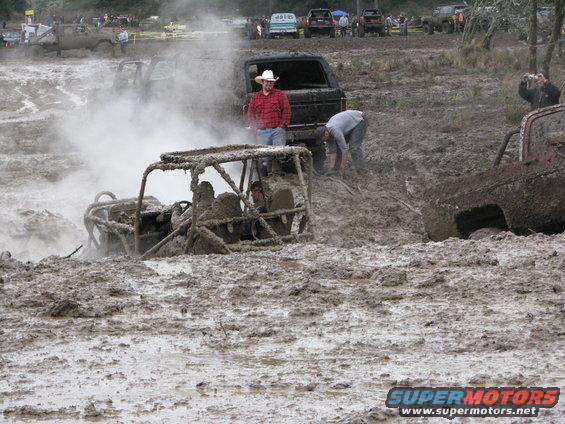 Off-road buggy stuck in mud with people around
