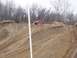 2004 Jeep Wrangler - A red SUV navigates a challenging dirt incline with visible tire tracks.
