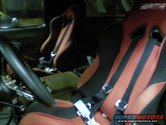 Bucket seats with red and black upholstery and racing harnesses