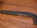 1996 Ford Bronco - A dark, possibly metal, vehicle component rests on a wooden surface.