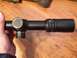 1996 Ford Bronco - A rifle scope is held in hand, showing adjustment turrets and markings.