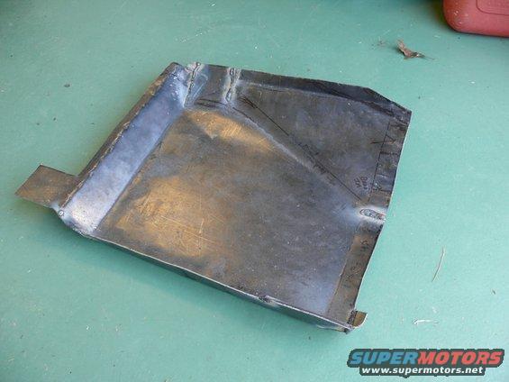 Metal floor pan with cut lines and welds, possibly for a car