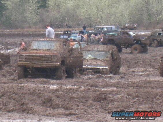 Mud-covered trucks stuck in a muddy field