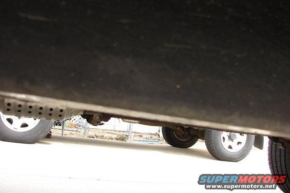 Underbody of a 2004 Toyota Tacoma showing the exhaust pipe and rear wheel