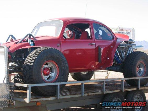 Red custom off-road VW Beetle on a trailer, exposed engine, big tires