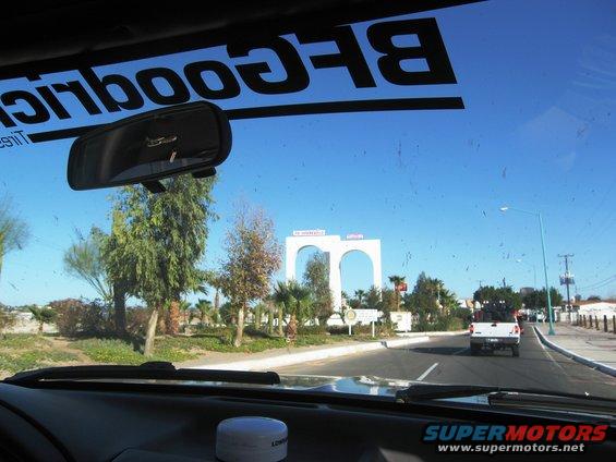 White pickup truck with spare tires on its bed, seen from inside a vehicle