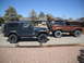 1986 Ford Bronco II - Two off-road vehicles, a Jeep Wrangler and a Ford Bronco II, are parked side-by-side in a driveway.