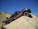 1986 Ford Bronco II - Two off-road vehicles navigate a steep, sandy incline under a clear blue sky.