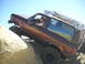 1986 Ford Bronco II - Ford Bronco II navigates rocky terrain under a clear blue sky.