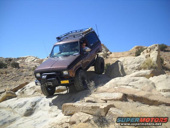 Brown 1986 Ford Bronco II off-roading on rocky terrain