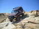 1986 Ford Bronco II - This 1986 Ford Bronco II navigates a challenging rocky trail under a clear blue sky.