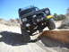 1986 Ford Bronco II - This 1986 Ford Bronco II navigates a challenging off-road obstacle on a sunny day.