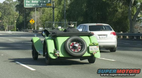 Green vintage convertible with spare tire on rear, California license plate TAG 9061