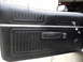1973 Ford Ranchero - Close-up of a vintage car's black vinyl door panel, showing ribbed texture and chrome accents.