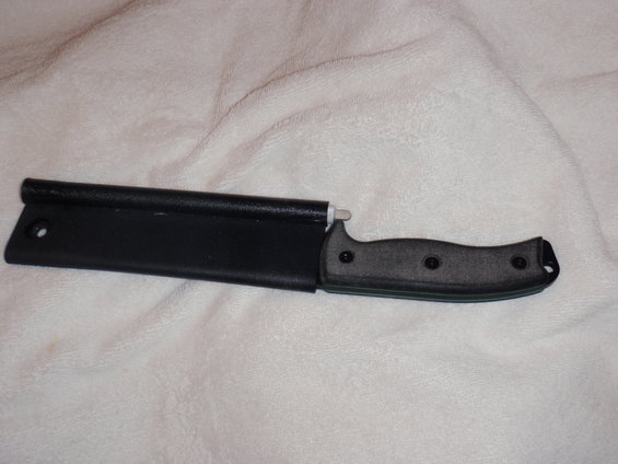 Knife with textured handle partially inserted into a black sheath