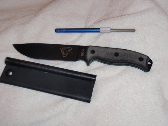 Black fixed-blade knife with gray handle, black sheath, and blue sharpening rod
