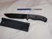 1991 Ford Bronco - Knife with sheath and sharpening rod on a white textured surface.
