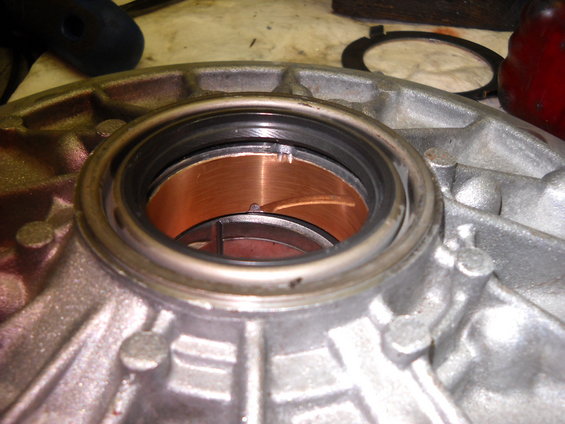 Close-up of transmission part with copper-colored bearings and a black seal
