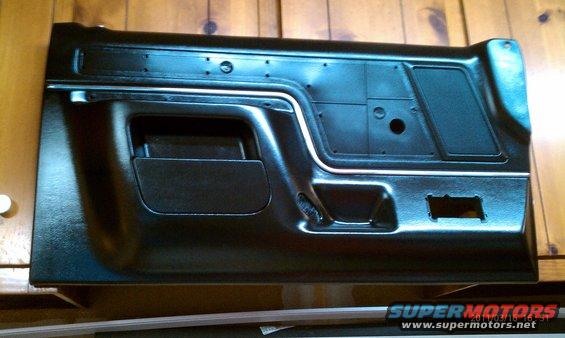 Black interior door panel with chrome trim and storage pocket