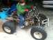 2001 Honda TRX 90 - A young child sits on an ATV in a garage.
