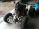 2001 Honda TRX 90 - A four-wheeler ATV is parked inside a garage with a person seated on it.