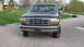 1992 Ford Bronco - The front grille and headlights of a 1992 Ford Bronco are visible in this outdoor photograph.