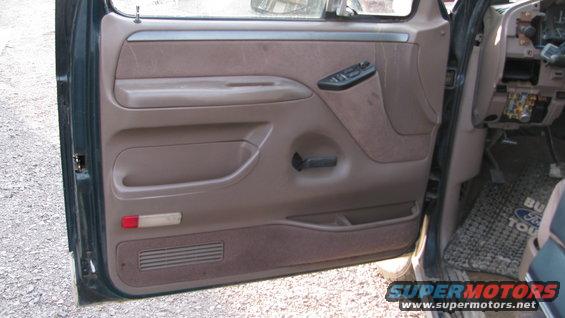 1992 Ford Bronco interior door panel with brown fabric and plastic trim, showing window controls and door handle