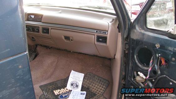 1992 Ford Bronco interior showing dashboard, floor mats, and removed door panel with wiring