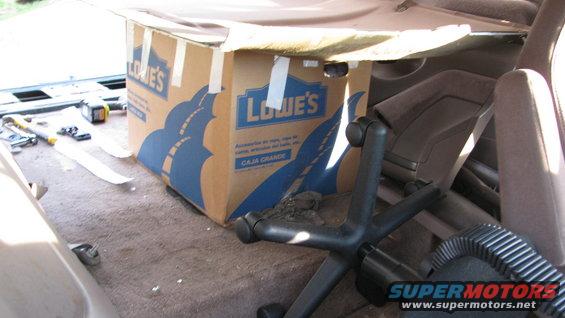 Interior shot of a vehicle's cargo area with a Lowe's box and an office chair