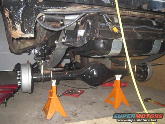 Rear axle assembly with leaf springs and brake drums supported by jack stands