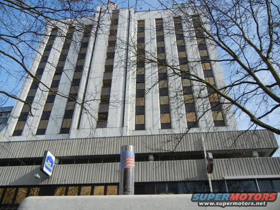 Building facade with bare tree branches and a cylindrical object with American flag pattern