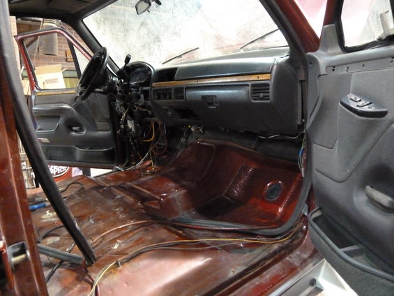 Truck interior with removed carpet, exposed wiring, and bare metal floor