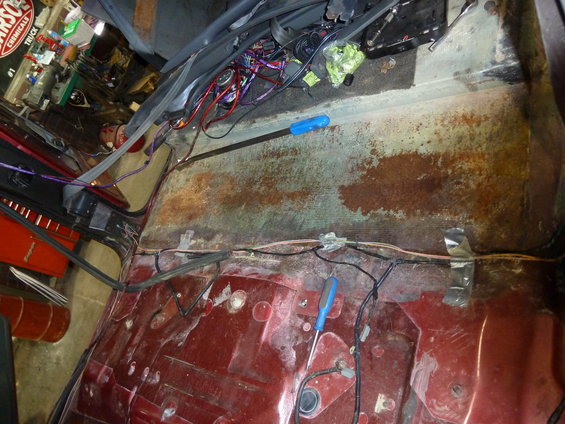 Interior floor of a vehicle with exposed wiring and rust