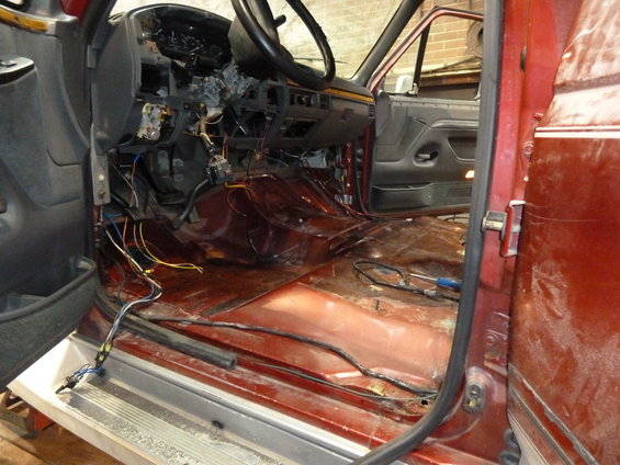 Vehicle interior with dashboard removed, exposing wires and floor