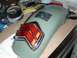 1980 Honda CB750 - A motorcycle fender and taillight assembly sits on a workbench next to a tachometer.