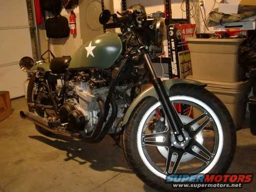 Green motorcycle with a white star on the tank, parked indoors