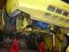 1979 Ford Mustang - Underside view of a yellow vehicle, showing the steering rack and suspension components, supported by red jack stands.
