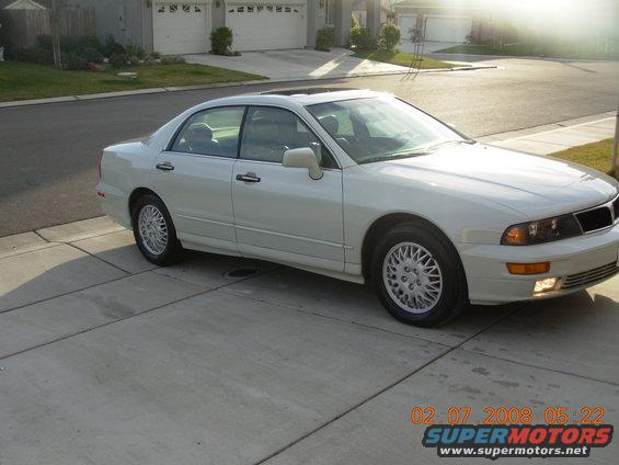 White 1999 Mitsubishi Diamante sedan parked on a concrete driveway, front 3/4 view