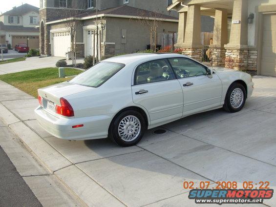White 1999 Mitsubishi Diamante sedan parked in a driveway, viewed from the rear passenger side