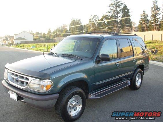 Green 1997 Ford Explorer SUV parked on a street, front 3/4 view