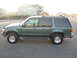 1997 Ford Explorer - The side profile of a green 1997 Ford Explorer is shown with tinted windows and running boards.