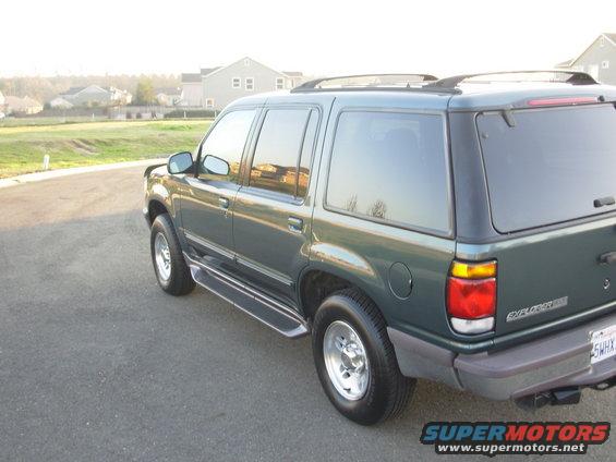 Dark green 1995 Ford Explorer SUV parked on asphalt, rear quarter view